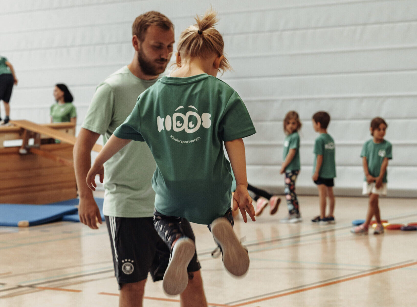 Aktiver Sportkurs bei KiDDs – Kursleiter:in motiviert Teilnehmer beim Präventionssport